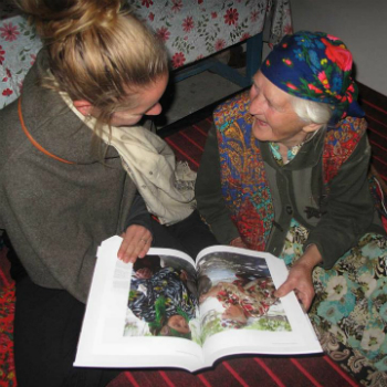 Jamila (left) shares the finished cookbook with a member of the community.