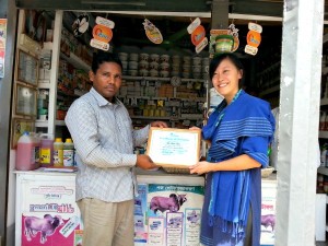 The author, IMM Fellow Jenn Wong, presenting a certificate of training to one of the shop owners in CARE Bangladesh's social enterprise, Krishi Utsho.