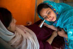 Zahida bano, CMW Sumal, Ghizer is using a Pinard horn to listen the heart rate of a fetus during pregnancy of her patient: Shabam. The tools are provided by Mother Care and Child Survival (MCCS) project, which helped her provide excellent antenatal and postnatal treatment.