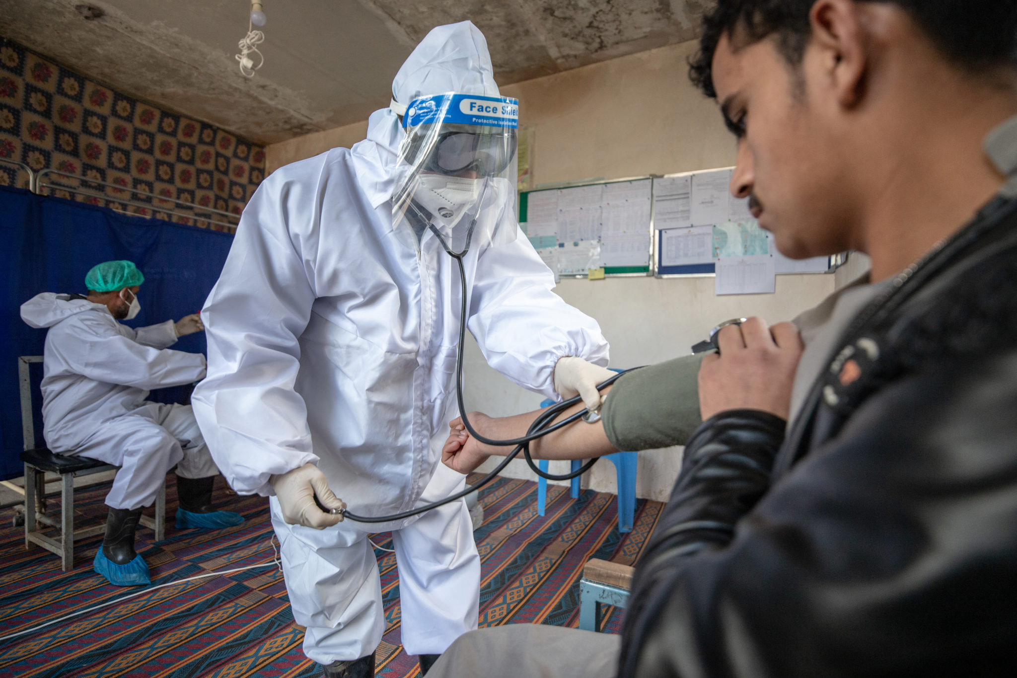 A healthcare worker checks the patient's condition before conducting a COVID-19 test.