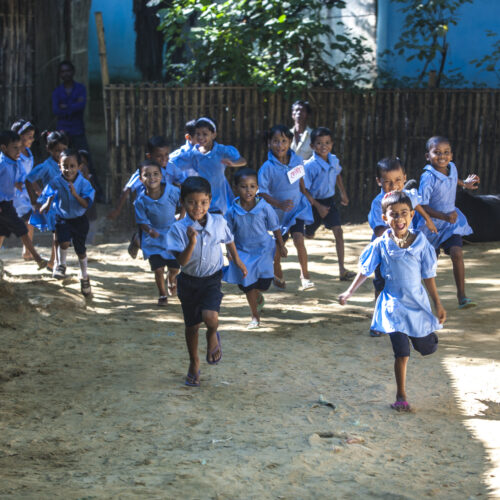 Students run to their Pre-school in Malinchora Village. Bangladesh.