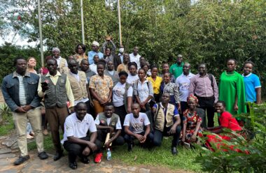 A large group of participants stand outside for a photo.