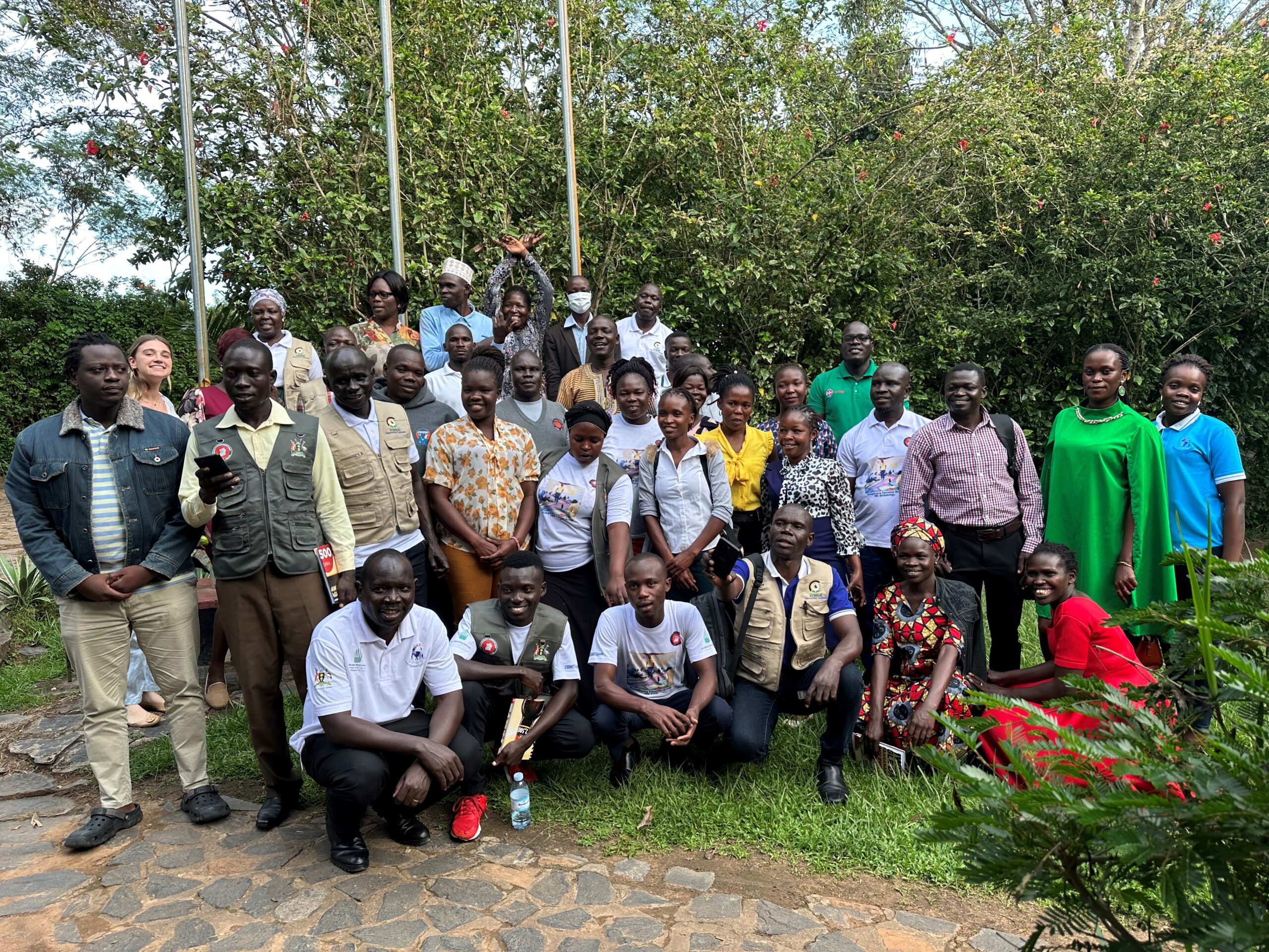 A large group of participants stand outside for a photo.