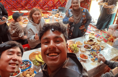 A group of young people  gathered around a table wit
