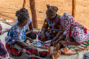 Caption: Fatima Fernando, a Women's Change Group Influencer, discusses issues raised in the printed material with fellow attendees of the session.

Location: Nanhupo Village, Montepuez

Country: Mozambique

Project: SPARC

Institution: Aga Khan Foundation Canada